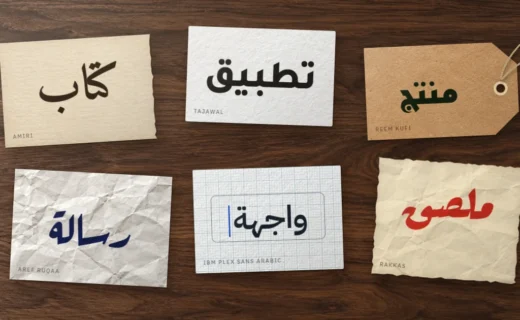 Six paper scraps on a walnut desk, each with one Arabic word in Amiri, Tajawal, Reem Kufi, Aref Ruqaa, IBM Plex Sans Arabic or Rakkas
